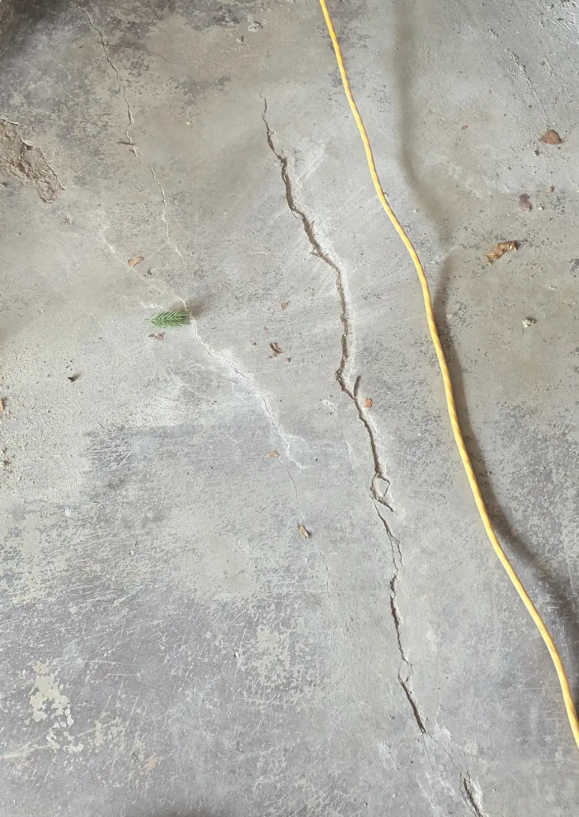 Close-up of a crack running across a concrete slab surface -- PolyJacks concrete leveling serving Olathe, KS.