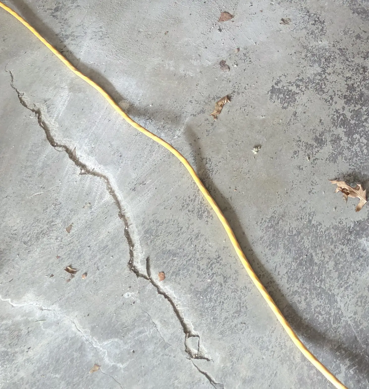 A residential concrete slab with settlement cracking -- PolyJacks concrete leveling serving Overland Park, KS.