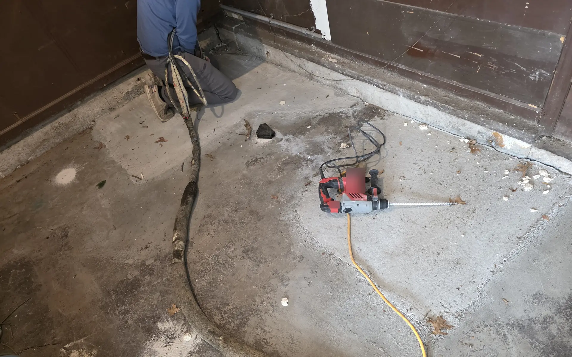 Drilling a small injection port into a concrete slab with a rotary hammer drill -- PolyJacks concrete leveling serving Kansas City, KS.